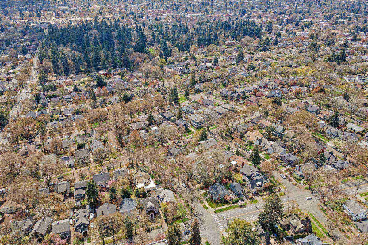 This image offers a peaceful view of a residential Portland neighborhood with tree-lined streets, green spaces, and a welcoming community atmosphere. The leafy surroundings evoke a sense of outdoor relaxation and eco-conscious living within an urban context.